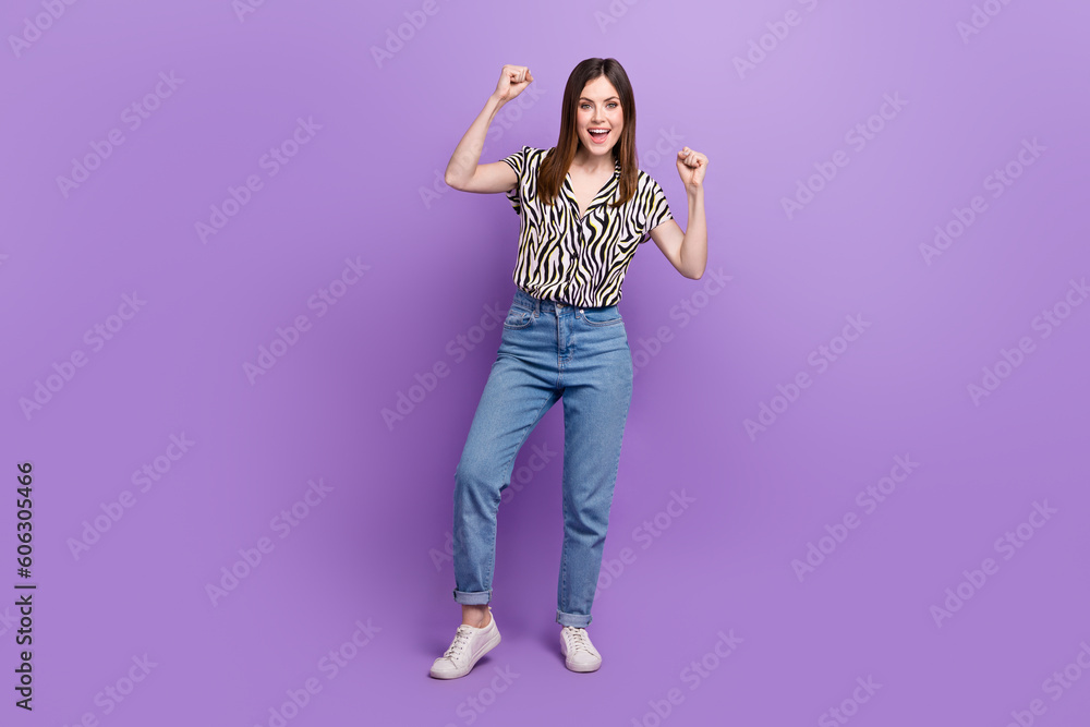 Full photo of young overjoyed girl fists celebrate her favorite fashion model demonstrate her clothes isolated on purple color background Full photo of young overjoyed girl fists celebrate her favorite fashion model demonstrate her clothes isolated on purple color background