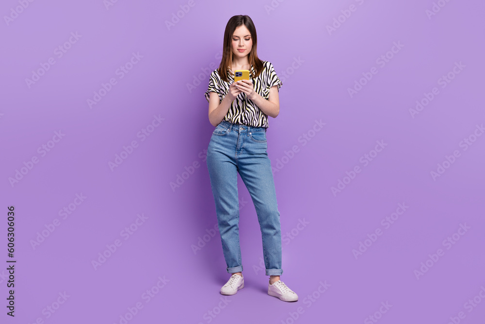 Full size photo of charming girl hold use smart phone chatting write blog post isolated on violet color background Full size photo of charming girl hold use smart phone chatting write blog post isolated on violet color background