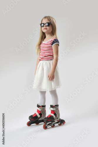 Studio portrait of beautiful bonde little girl in roller blades 