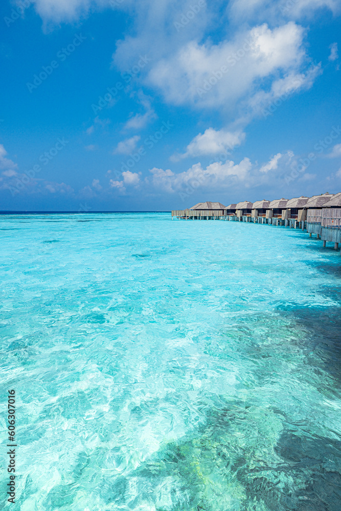 Panoramic landscape of Maldives beach. Exotic vacation seascape water villas bungalows resort with wooden pier bridge. Luxury travel destination. Fantastic turquoise blue ocean lagoon bay sunny sky