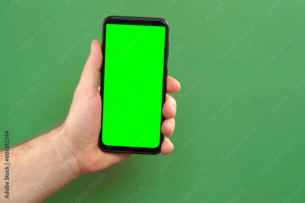 Young man hand use smartphone with green screen on green background. Gestures pack. Male hand touching, clicking, tapping swiping on black phone chroma key display. Close up Device. Modern Technology Young man hand use smartphone with green screen on green background. Gestures pack. Male hand touching, clicking, tapping swiping on black phone chroma key display. Close up Device. Modern Technology