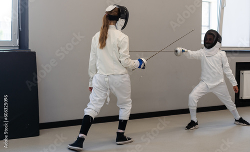Fencer woman with fencing sword. Fencers duel concept.