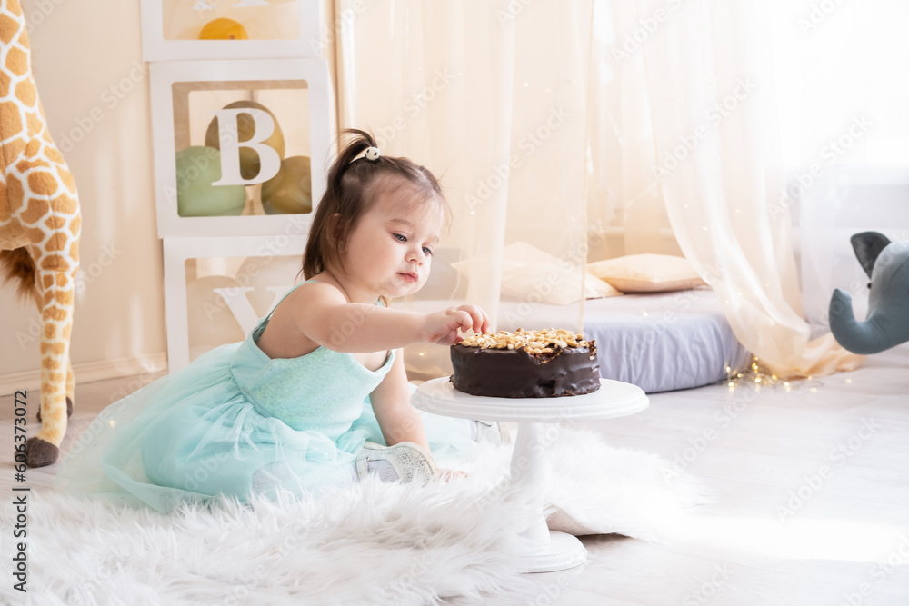 cute little child girl eating chocolate birthday cake and celebrating birthday