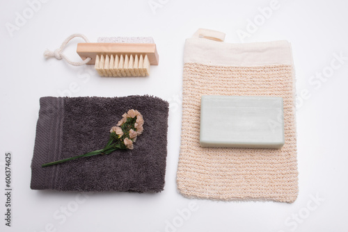 Light green colored soap and towels still life with a small flower, wellness accessories.