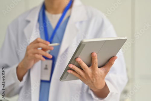 Doctor in white coat hand holding digital tablet, using the internet or web for medical search online