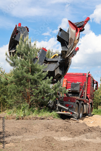 Tree transplanter heavy machine. machine for transplanting large trees. Planting large spruce trees in the park.  Landscaping, spring agricultural engineering, trees landing machines. Agrotechnology