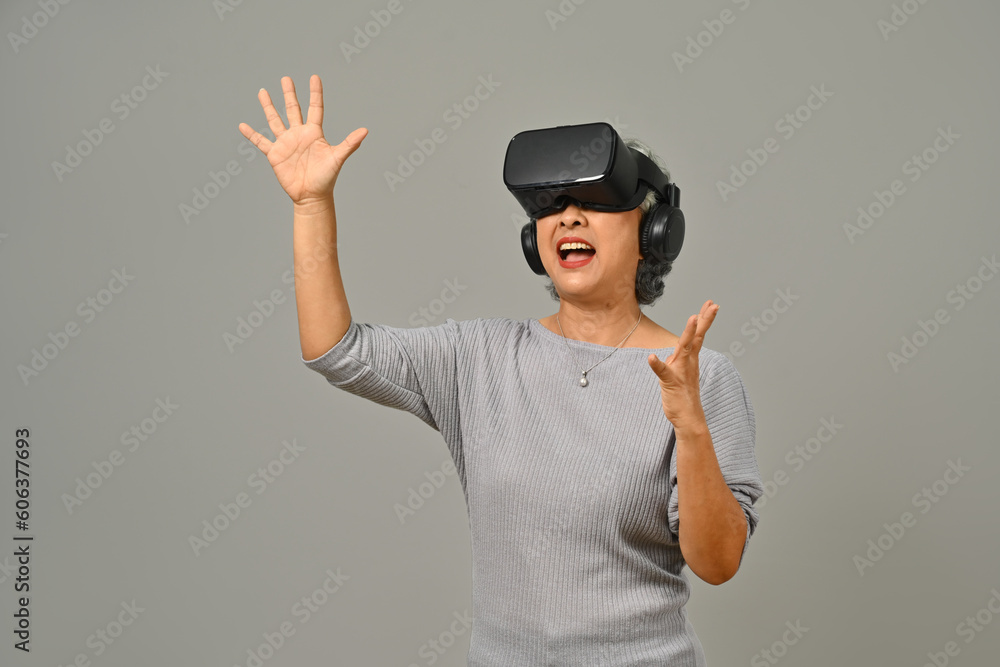 Portrait of amazed senior woman VR headset enjoying virtual reality experience. Modern technologies, innovations and gadgets Portrait of amazed senior woman VR headset enjoying virtual reality experience. Modern technologies, innovations and gadgets
