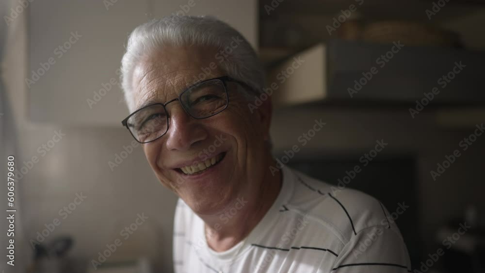 Close-up face of a happy senior man smiling. A mature man with gray hair standing in kitchen in domestic lifestyle Close-up face of a happy senior man smiling. A mature man with gray hair standing in kitchen in domestic lifestyle