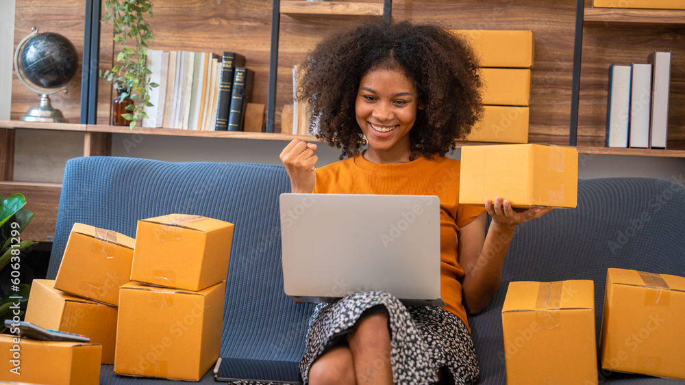 African American business woman working at warehouse preparing SME package box for delivery at small business home office. African American business woman working at warehouse preparing SME package box for delivery at small business home office.