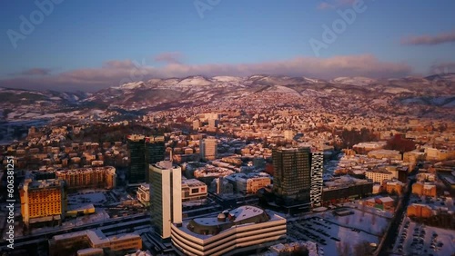 Aerial cinematic drone snowy roads winter Olympic downtown snowy frozen Sarajevo City town center Bosnia and Herzegovina landscape afternoon sunset golden purple circle right movement photo