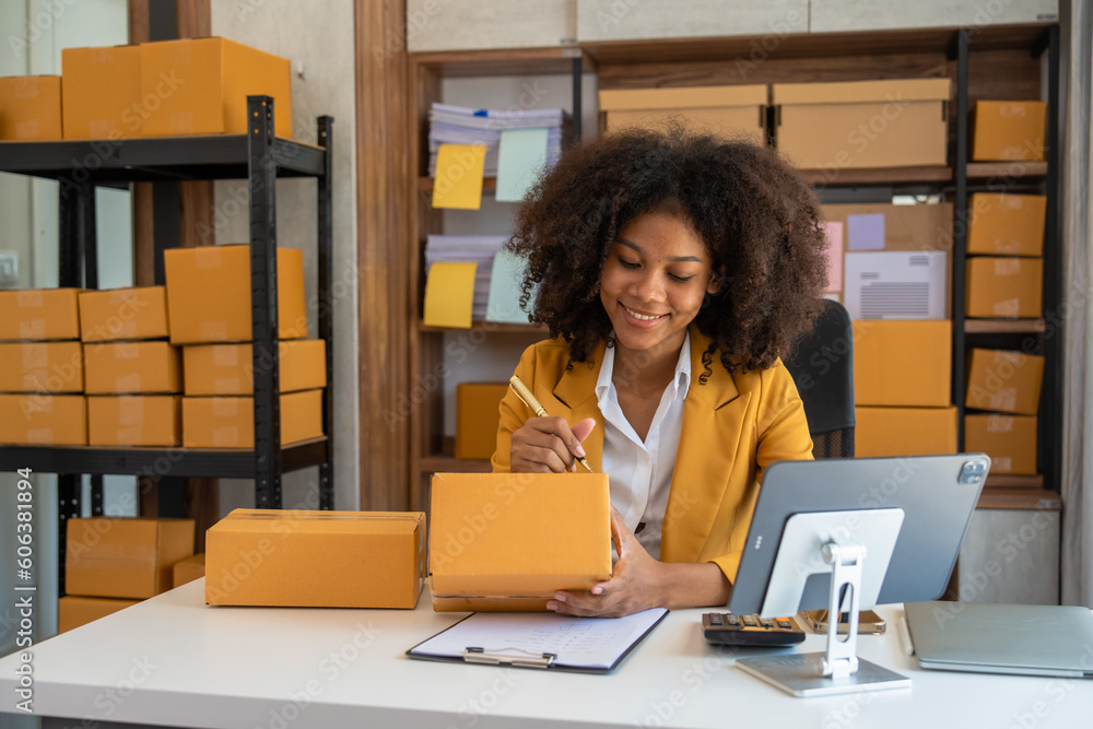 Φωτογραφία African American business woman working at warehouse preparing SME package box for delivery at small business home office