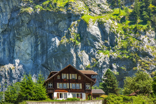 Old wooden house with flowers on the balcony in Swiss Alps