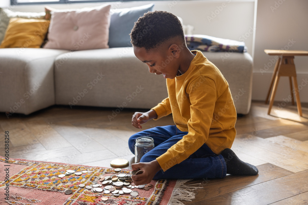 Young boy counting coins saved in an old jar Young boy counting coins saved in an old jar