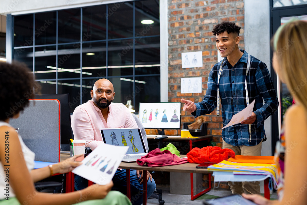 Happy diverse fashion designers discussing fashion projects at meeting in creative office, unaltered Happy diverse fashion designers discussing fashion projects at meeting in creative office, unaltered