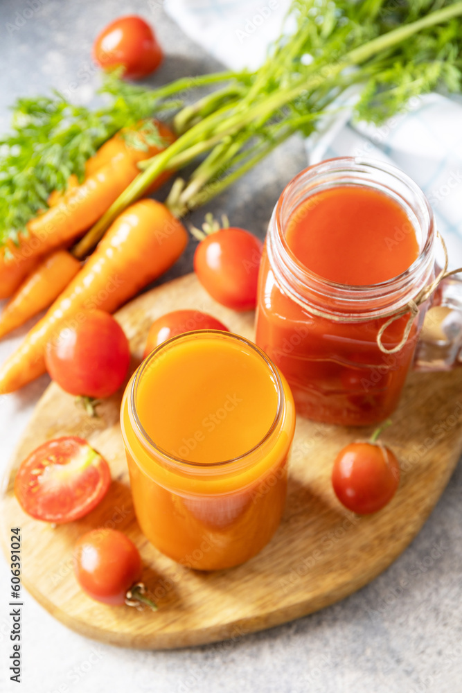 Vitamins drinks juice carrot and tomato. Tomato and carrot juice in a glasses on a stone table. Healthy lifestyle. Vitamins drinks juice carrot and tomato. Tomato and carrot juice in a glasses on a stone table. Healthy lifestyle.