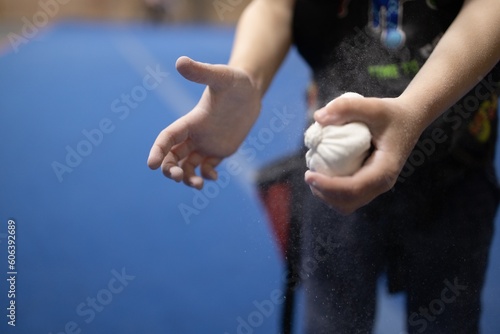 Closeup shot of a male preparing to go rock climbing rubbing his hands with chalk
