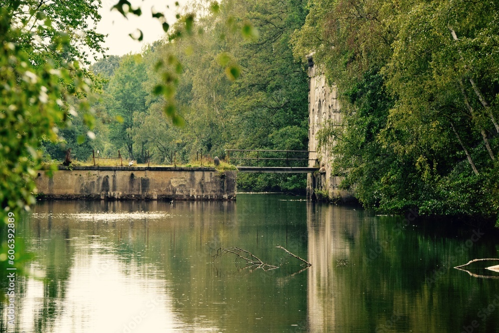 View of the river with a small bridge surrounded by green vegetation. Antwerp, Belgium. View of the river with a small bridge surrounded by green vegetation. Antwerp, Belgium.