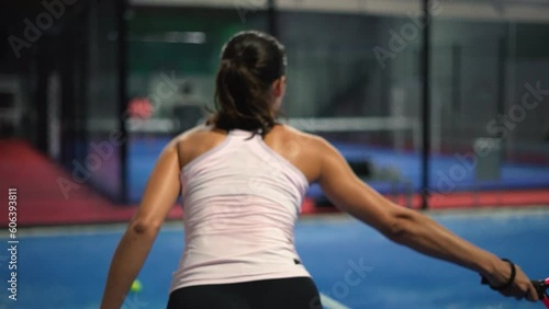 Young sportswoman and man couple playing padel tennis in slow motion. Hitting padel ball in slow mo at padel court. photo