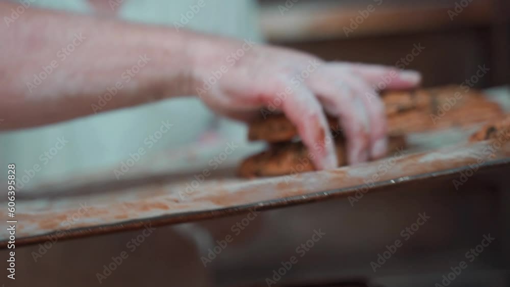 small dumplings with grains come fish out of the oven of a bakery and are sorted onto a tray small dumplings with grains come fish out of the oven of a bakery and are sorted onto a tray