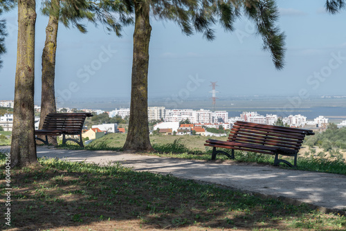 Path in the park with wooden benches on a background of the city of Loures, Portugal photo