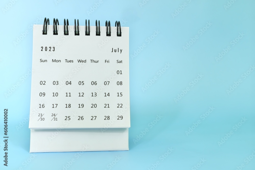 Selective focus of July 2023 desk calendar on blue background with copy space.