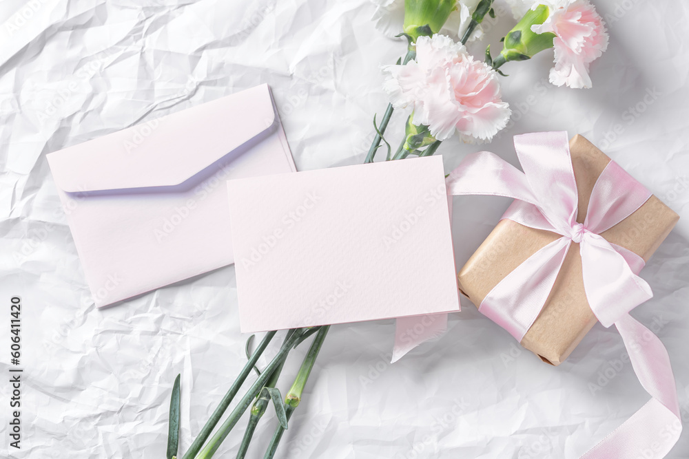 Pink blank card and envelop with flowers and gift box on crumpled texture background Pink blank card and envelop with flowers and gift box on crumpled texture background