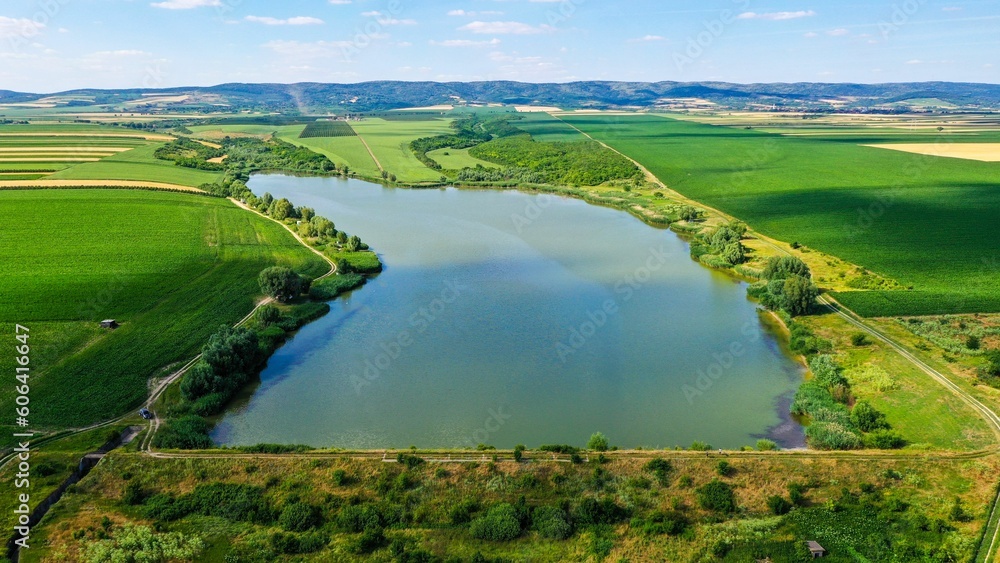 Drone shot of Vranjas lake in green field of Mandjelos village, Serbia
