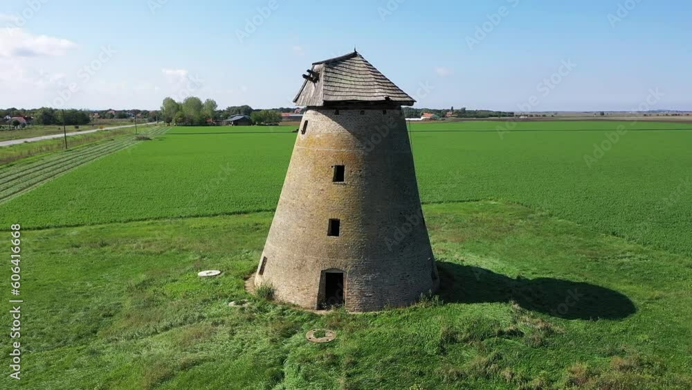 Beautiful view of an old stone windmill in the middle of an evergreen field in Melenci, Siberia Beautiful view of an old stone windmill in the middle of an evergreen field in Melenci, Siberia