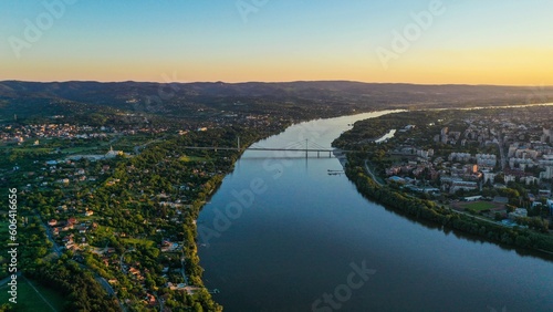 Aerial view of Novi Sad cityscape with river and Liberty bridge at sunset