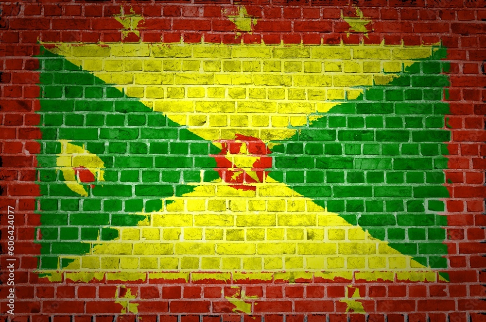 Shot of the Grenada flag painted on a brick wall in an urban location Shot of the Grenada flag painted on a brick wall in an urban location