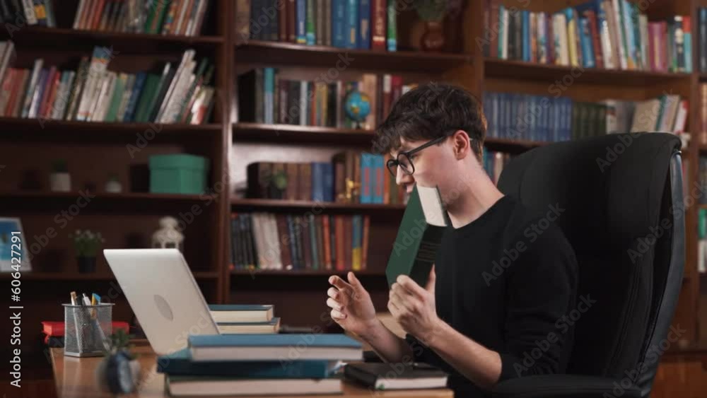 A man is talking to someone on a video call. He has many books on his table, and he showcases some of them on camera. Toward the end, he takes out money and displays it on the camera. A man is talking to someone on a video call. He has many books on his table, and he showcases some of them on camera. Toward the end, he takes out money and displays it on the camera.