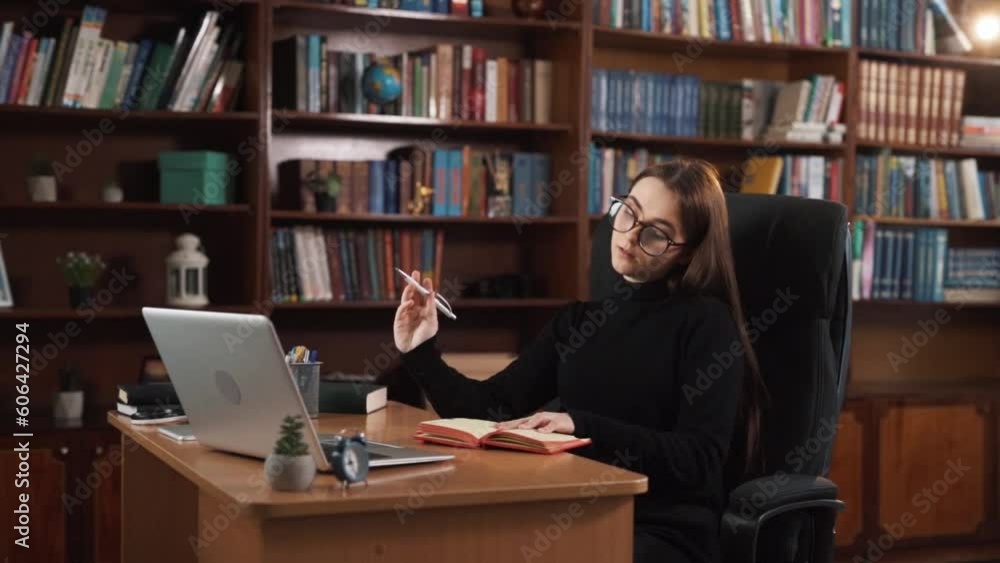 The girl sits at the table, picks up a pen, and writes something in her notebook, she periodically pauses to think, says her thoughts aloud, and writes it down in her notebook again. The girl sits at the table, picks up a pen, and writes something in her notebook, she periodically pauses to think, says her thoughts aloud, and writes it down in her notebook again.