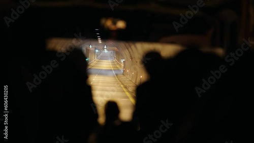 Passenger pov of buss with silhouettte tourist people driving through tunnel photo