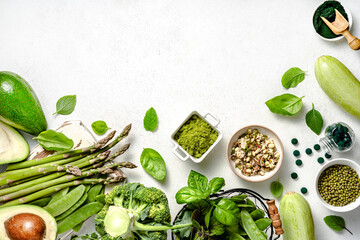 Vegetarian healthy green food on white background. Products for vegans and vegetarians containing vegetable protein. Green peas, beans, mung beans, broccoli, zucchini, avocados, matcha, spinach.