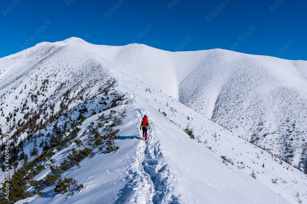 Young woman enjoying stunning view over winter Mountains with snow covered peak in Tatras mountain in Slovakia and Poland Europe.