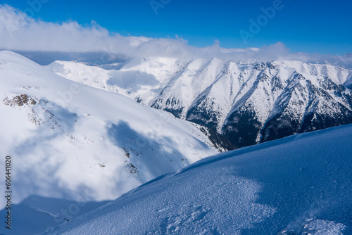 Black and white panorama of high snow-capped mountain peaks and beautiful sky with clouds at sun windy day. Caucasus Mountains in winter, region Slovakia, mount Baranec in West Tatras mountain in slo photo