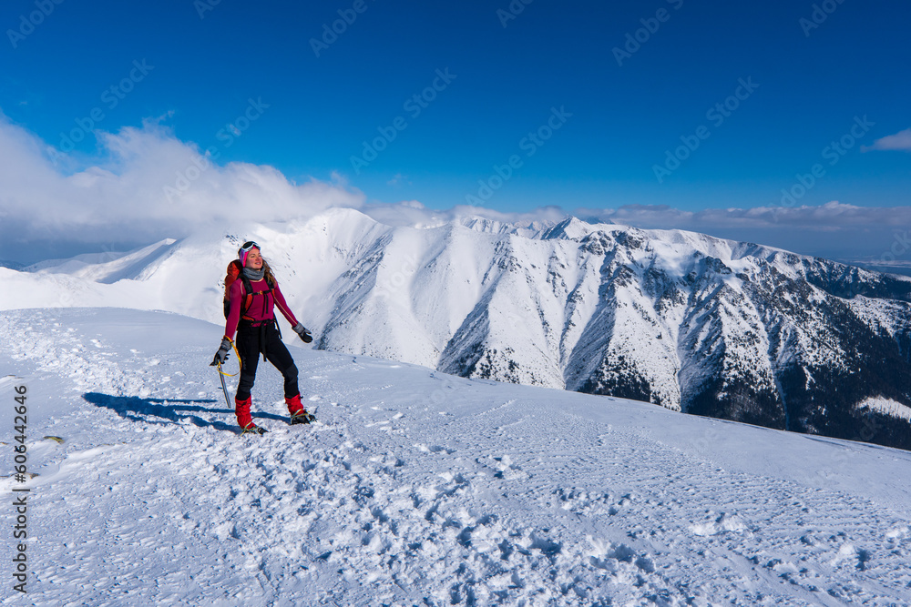 Happy woman relaxing on the top of mountain under blue sky with sunlight at sunny winter day, travel vacation, landscape mountains background.