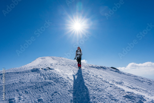 Winter travel vacation concept, Silhouette of young happy traveler european woman with gloves relax on mountain with sun.