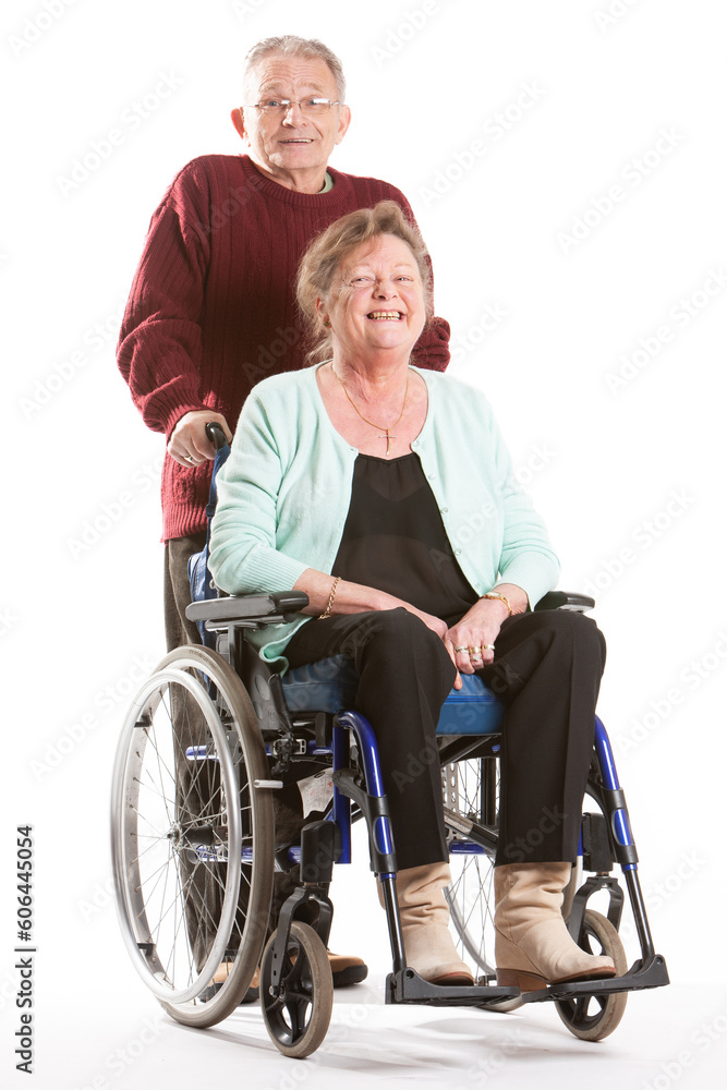 Senior Citizens: Care and Attention. A smiling senior lady in her wheelchair with her partner carer. Full length portrait, isolated on white. Senior Citizens: Care and Attention. A smiling senior lady in her wheelchair with her partner carer. Full length portrait, isolated on white.