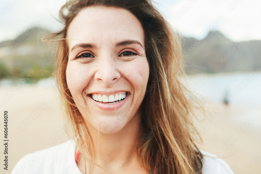 Happy latin young woman smiling with beach on background - Joyful girl taking selfie picture with mobile phone outside during summer travel vacation - Healthy lifestyle concept Happy latin young woman smiling with beach on background - Joyful girl taking selfie picture with mobile phone outside during summer travel vacation - Healthy lifestyle concept