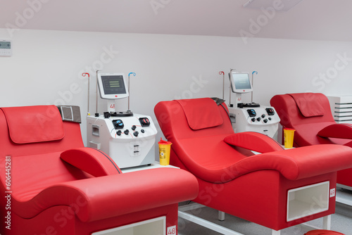 comfortable medical chairs with ergonomic design near plastic cups and automated transfusion machines with touchscreens in sterile environment of blood donation center photo