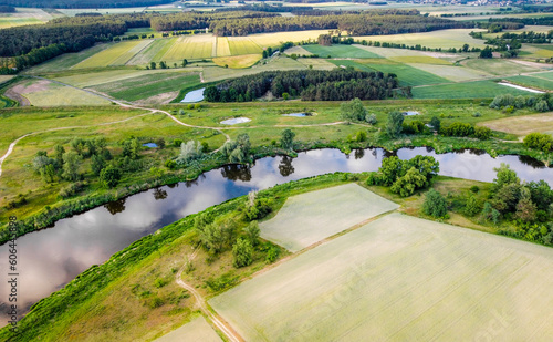 Panorama of the Greater Poland Voivodeship. Top view of fields meadows river and woods. Drone view. Warta river.