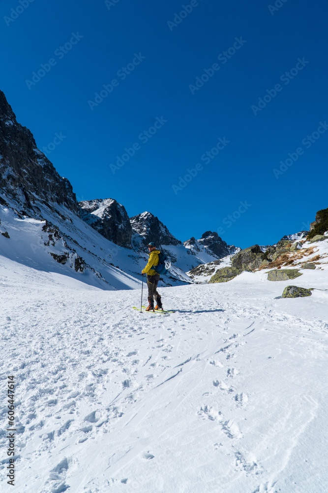 A skier is walking up the hill. Skitouring in Alps. Sunny weather.