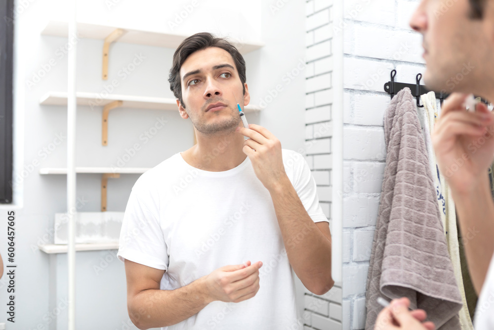 Handsome man doing facial injections himself at home Handsome man doing facial injections himself at home