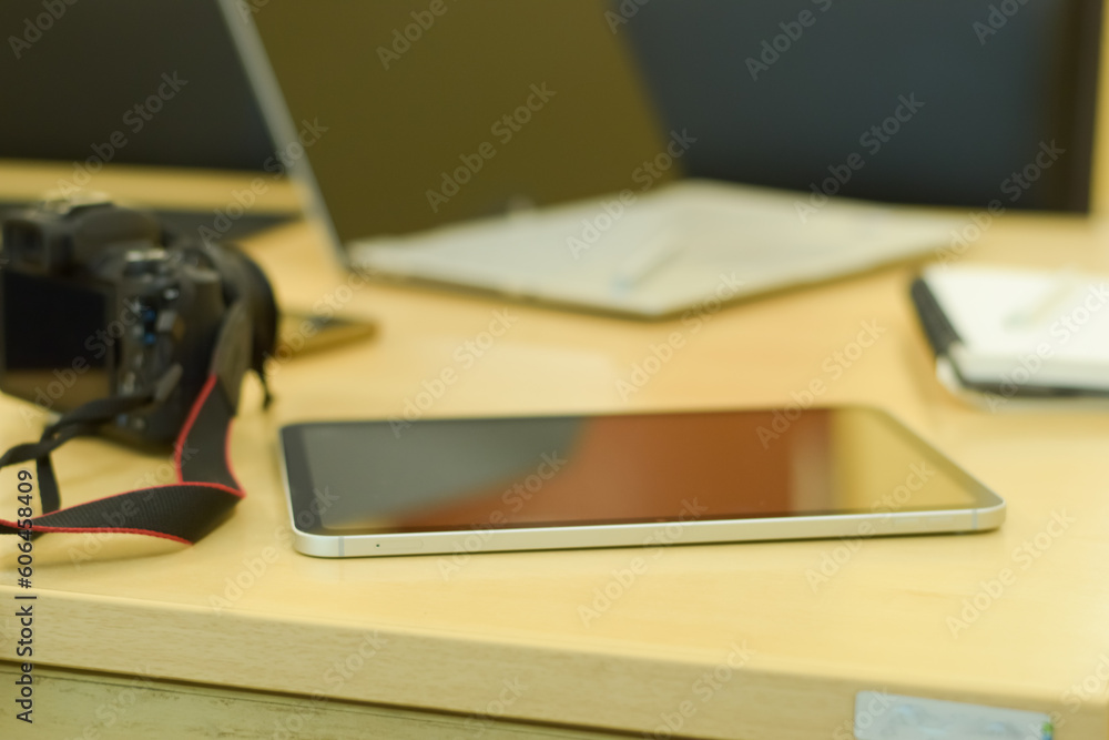 Electronics items on a table, tablet, laptop, pencil, pen, mobile and a note keeping book Electronics items on a table, tablet, laptop, pencil, pen, mobile and a note keeping book