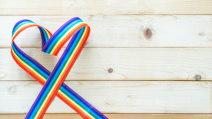 LGBT, LGBTQ for gay pride month and International Day Against Homophobia, Transphobia and Biphobia with rainbow ribbon awareness on white wood background