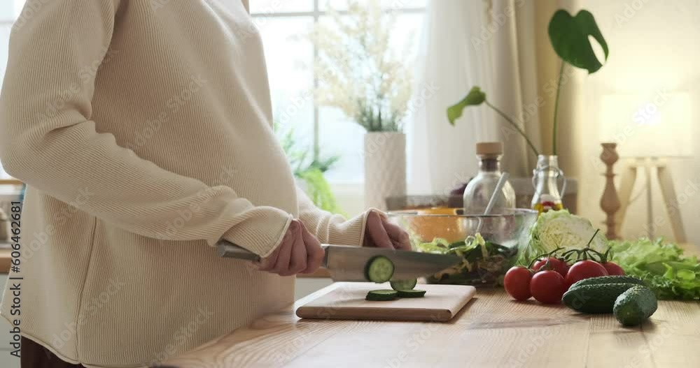 Pregnant Caucasian woman at kitchen, preparing fresh salad. She assembles ingredients in bowl. She lovingly strokes her belly, embracing joy of motherhood and nourishment provided. Pregnant Caucasian woman at kitchen, preparing fresh salad. She assembles ingredients in bowl. She lovingly strokes her belly, embracing joy of motherhood and nourishment provided.