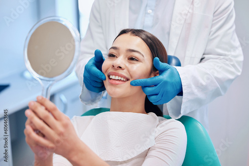 Dentist, mirror and woman check smile after teeth cleaning, braces and dental consultation. Healthcare, dentistry and happy female patient with orthodontist for oral hygiene, wellness and cleaning photo