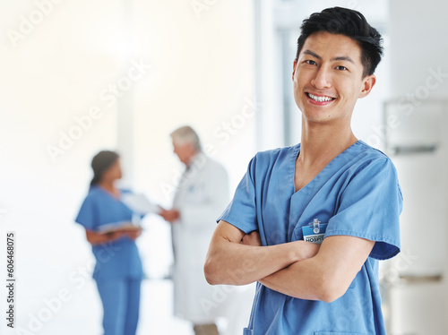 Portrait, happy man and Asian nurse with arms crossed in hospital or clinic. Face, confidence and medical professional, male surgeon or doctor with pride for career, job and healthcare for wellness.