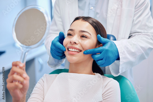 Dentist, mirror and woman with smile after consulting for teeth whitening, service and dental care. Healthcare, dentistry and female patient with orthodontist for oral hygiene, wellness and cleaning photo
